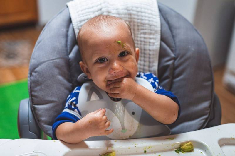 A baby enjoying a messy breakfast